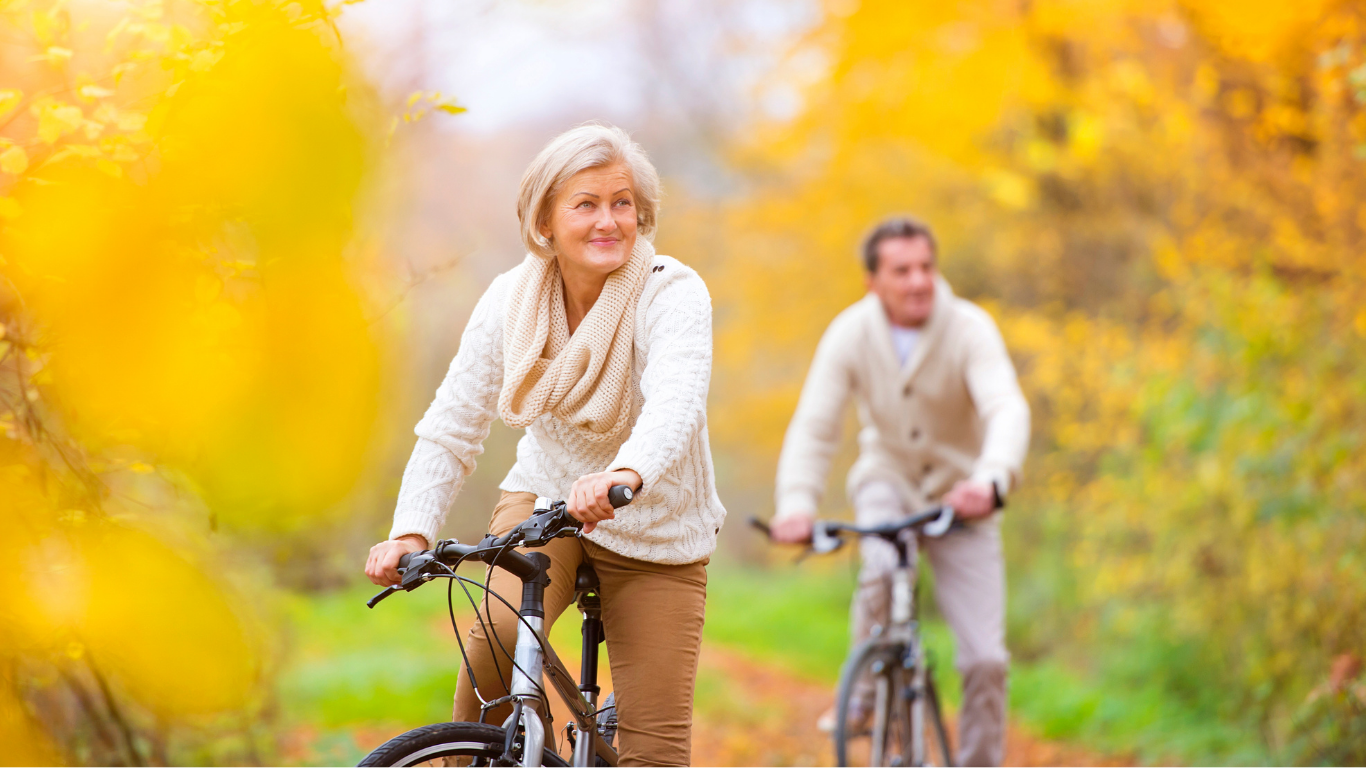 older couple riding bikes in the park