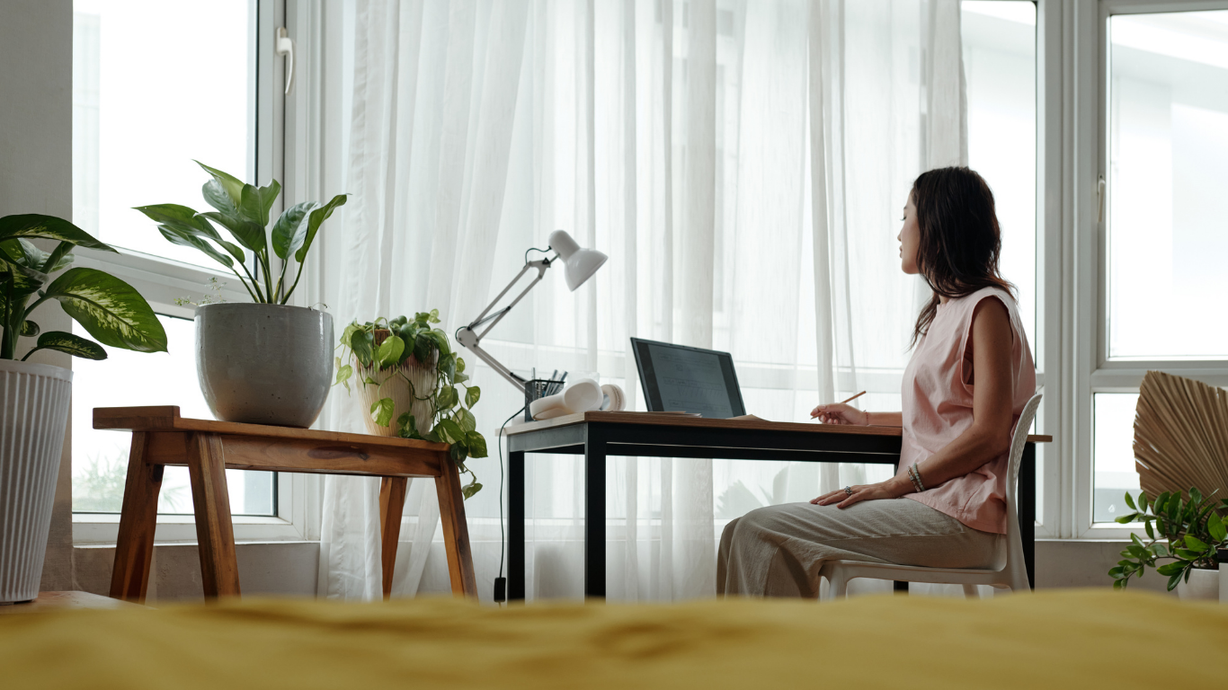 women sitting at her computer pondering deeply about retirement